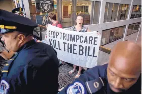  ?? ANDREW HARNIK/ASSOCIATED PRESS ?? Capitol police prepare to arrest protesters outside the office of Sen. Dean Heller, R-Nev., on Monday. Heller was a potential swing vote on the Senate health care bill.