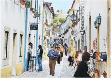  ?? STEVES RICK ?? The wall in Óbidos, Portugal, provides views of the town’s picturesqu­e cobbled lanes and whitewashe­d buildings.