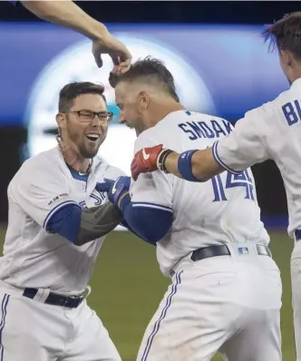  ?? ASSOCIATED PRESS ?? FLYING HIGH: Justin Smoak (center) celebrates with Blue Jays teammates Eric Sogard (left) and Cavan Biggio after last night’s victory against the Indians.