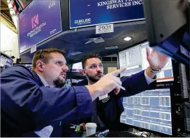  ?? SPENCER PLATT / GETTY IMAGES ?? Traders work at the New York Stock Exchange on Tuesday, a day when the S&P 500 index slipped below its average price for the past 50 days. Walmart sank the most since 1988, while a rally in chipmakers boosted the Nasdaq 100 Index.