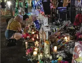  ?? JOSH SWEIGART / STAFF ?? Two women visit the memorial to the Oregon District shooting in the early hours Sunday — one week from the time a shooting rampage began that claimed nine lives and injured dozens more.