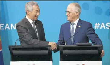  ?? Rick Rycroft Associated Press ?? SINGAPOREA­N Prime Minister Lee Hsien Loong, left, and Australian counterpar­t Malcolm Turnbull shake hands at a closing news conference during the ASEAN summit on Sunday in Sydney, Australia.