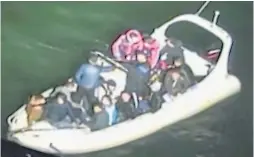  ??  ?? A photo taken by the rescue helicopter of the boat listing off the Kent coast crammed with illegal migrants who paid to cross over from Calais