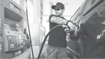 ?? PHOTOS BY ROBERT HANASHIRO, USA TODAY ?? Jayson Bernal, 31, fuels his truck at a Chevron station off Interstate 5 near Los Angeles. Gas prices may rise in the short term.