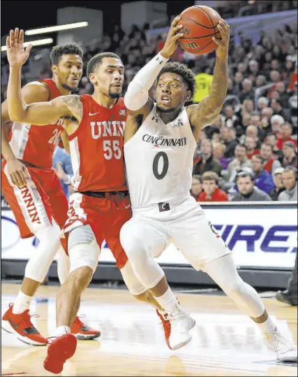  ?? Kareem Elgazzar The Associated Press ?? Elijah Mitrou-Long (55), who led the Rebels with 29 points, defends as Cincinnati’s Chris McNeal (0) drives in the first half of their clash Saturday in Cincinnati.