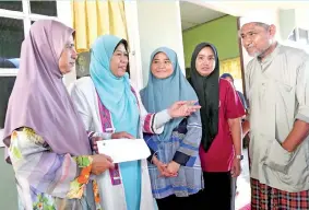  ??  ?? ZURAIDA bertemu dengan Mohd Kassim Abdul Hamid dan isteri Asma Aziz bersama dua anak mereka ketika menziarahi keluarga Allahyarha­m Muhammad Adib, di kediaman mereka di Kampung Tebengau, pada Ahad. -Gambar Bernama