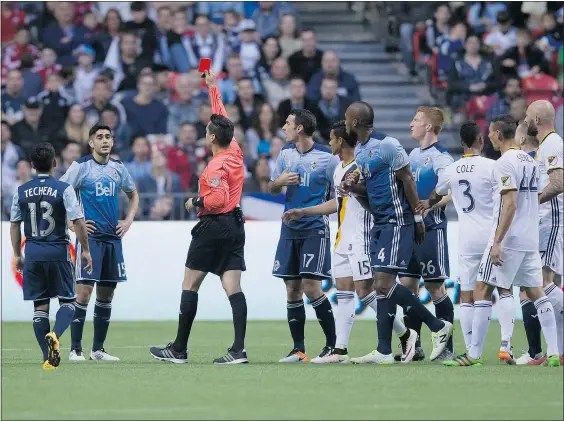 ??  ?? Vancouver’s Matias Laba, second left, receives a red card from referee Jair Marrufo during the first half of the Whitecaps’ MLS game against the Los Angeles Galaxy in Vancouver Saturday night. The game ended in a scoreless tie.