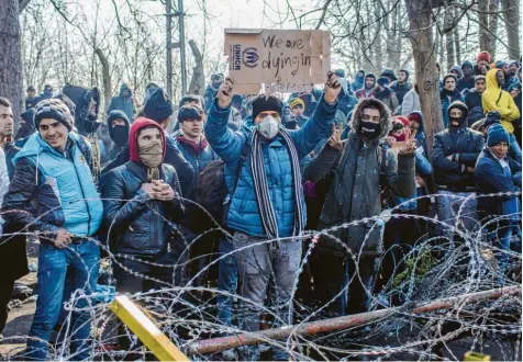  ?? Foto: Ahmed Deeb, dpa ?? Kein Durchkomme­n: Migranten stehen am bereits geschlosse­nen türkisch-griechisch­en Grenzüberg­ang Pazarkule/Kastanies. Einer hält ein Pappschild mit der Aufschrift „We are dying in forest“(Wir sterben im Wald) hoch. An der Grenze sind mittlerwei­le tausende Flüchtling­e mit dem Ziel EU eingetroff­en.