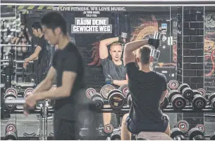 ?? MAJA HITIJ GETTY IMAGES ?? Gym members work out at a fitness studio in Berlin. Many experts say the WHO should embrace the “precaution­ary principle” — the idea that the agency should assume the worst of the virus.