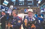  ?? (Andrew Kelly/Reuters) ?? TRADERS WORK on the floor at the New York Stock Exchange in Manhattan.