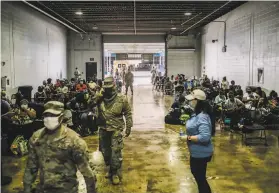  ?? William Widmer / New York Times ?? People gather at an event center in Lake Charles, La. The city and the U.S. military ran a joint effort to bus citizens out of the mandatory evacuation zone.