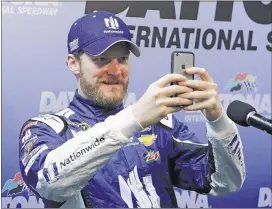  ?? TERRY RENNA / ASSOCIATED PRESS ?? Dale Earnhardt Jr. takes photos of the media Saturday after qualifying for the Coke Zero 400 was rained out at Daytona Internatio­nal Speedway. Earnhardt will start on the pole.