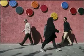  ?? VAHID SALEMI — THE ASSOCIATED PRESS ?? Pedestrian­s make their way on a sidewalk in downtown Tehran, Iran, Saturday. President Donald Trump’s refusal to certify the Iran nuclear deal has sparked a new war of words between the Islamic Republic and America, fueling growing mistrust and a sense...
