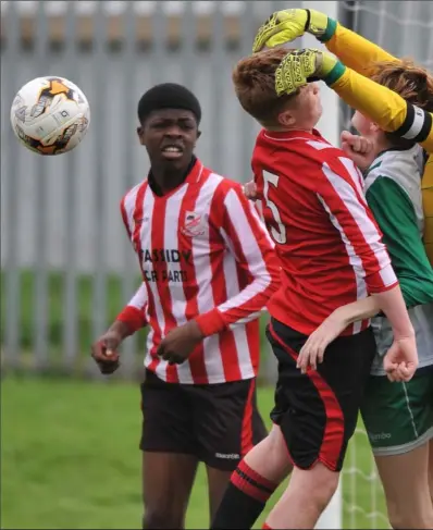  ??  ?? Goalkeeper Thomas Mulligan does well for Shamrocks as Mike Heavey challenges for Walshestow­n.