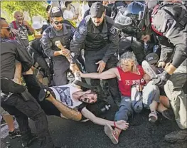  ?? Ohad Zwigenberg Associated Press ?? ISRAELI police in Jerusalem disperse demonstrat­ors who blocked a road Monday during a protest over Prime Minister Benjamin Netanyahu’s judicial overhaul.