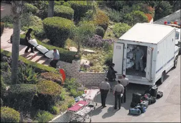  ?? NELVIN CEPEDA/SAN DIEGO UNION-TRIBUNE/TNS ?? Medical examiner’s office workers remove some of the 39 bodies found March 26, 1997, after a mass suicide in Rancho Santa Fe, Calif. Twenty years after the deaths of members of the Heaven’s Gate cult, researcher­s are considerin­g what lessons from that...