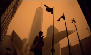  ?? ?? Smoke from wildfires in Canada envelops New York City, as a pedestrian walks near the World Trade Center in Manhattan on June 7