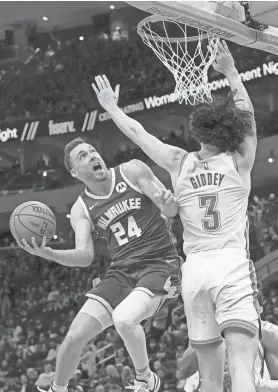  ?? MILWAUKEE JOURNAL SENTINEL MARK HOFFMAN / ?? Milwaukee Bucks guard Pat Connaughto­n scores on Oklahoma City Thunder guard Josh Giddey during the first half Sunday at Fiserv Forum.