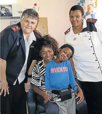  ?? / ARON HYMAN ?? A happy, smiling Mnotho in the arms of his mother, Mbali Mndebele, while showing off his heart ventricula­r assist device. On hand to offer support are Sisters Ina Kok and Bulelwa Ntilashe.