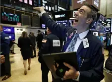  ?? Richard Drew/Associated Press ?? Trader Gregory Rowe laughs with fellow traders Wednesday as he works on the floor of the New York Stock Exchange.