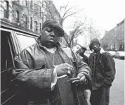  ?? Clarence Davis New York Daily News Archive via Getty Images ?? The Notorious B.I.G., a.k.a. Biggie Smalls, rolls a cigar outside his mother’s house in Brooklyn in 1995.