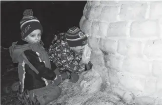  ?? CAROLE MORRIS-UNDERHILL ?? Kyler and Lucas Gillott, of Melanson, Kings County, were intrigued as they peered inside the 2019 Hantsport Winter Carnival igloo. Due to above seasonal temperatur­es last year, the igloo, which was built by volunteers, started to melt early.