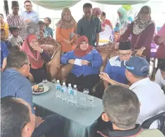  ??  ?? Rubiah (seated, centre) interacts with Kampung Baru villagers during her visit there.