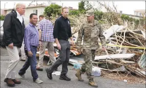  ?? Evan Vucci / Associated Press ?? President Donald Trump on Tuesday takes a walking tour to survey hurricane damage and recovery efforts in a neighborho­od in Guaynabo, Puerto Rico.