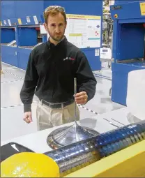  ?? STAFF ?? A Silfex employee at its Eaton plant shows a crystal grown in the facility. The company is expanding to Springfiel­d.