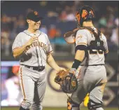  ??  ?? The San Francisco Giants’ Ty Blach is congratula­ted by catcher Buster Posey after Blach’s shutout of the Philadelph­ia Phillies on Friday night in Philadelph­ia.