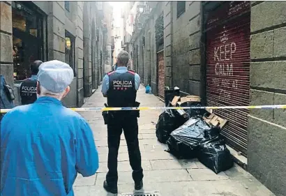  ?? LA VANGUARDIA ?? Un vecino asoma tras el cordón policial dispuesto por los mossos en la calle Groc, ayer por la tarde