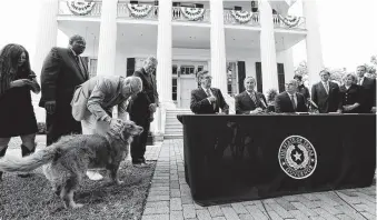  ?? Eric Gay / Associated Press ?? Gov. Greg Abbott’s dog Pancake joins lawmakers for a joint news conference Thursday announcing a legislativ­e deal to boost education spending and lower property tax bills.