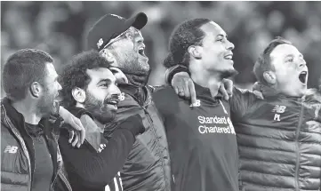  ?? - AFP photo ?? Liverpool’s Egyptian midfielder Mohamed Salah (2L), Liverpool’s German manager Jurgen Klopp (C) and Liverpool’s Dutch defender Virgil van Dijk celebrate after winning the UEFA Champions league semi-final second leg football match between Liverpool and Barcelona at Anfield in Liverpool, north west England.