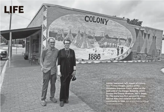  ?? PAM OLSON PHOTOS/SPECIAL TO THE OKLAHOMAN ?? Lonnie Yearwood, left, mayor of Colony, and Yvonne Kauger, justice of the Oklahoma Supreme Court, stand on the east side of the Kauger Building, which houses the Colony Museum, 105 E. Seger St. The mural was first painted by artist Patrick Riley and children from the community in 1994.