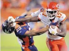  ?? DAVID ZALUBOWSKI/ASSOCIATED PRESS ?? Kansas City wide receiver Chris Conley, right, stiff arms Denver’s Chris Harris during the Chiefs win Monday night in Denver.