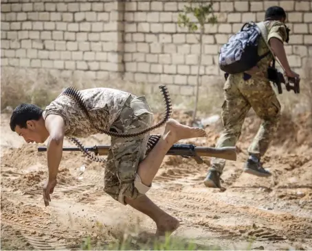  ?? AFP ?? Fighters loyal to the Tripoli administra­tion run for cover during clashes with forces loyal to eastern commander Gen. Khalifa Haftar south of Tripoli.