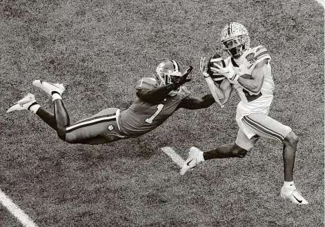  ?? Butch Dill / Associated Press ?? Ohio State WR Chris Olave gets behind Clemson CB Derion Kendrick to haul in a 56-yard TD pass from Justin Fields in the second half.