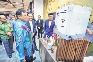  ??  ?? Abang Johari takes a closer look at the 3D printer during a tour of Saradise Innovation Space. With him are Uggah (left) and Chung (third left).