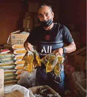  ?? (Foto Ghazali Kori/bh) ?? Peniaga kedai runcit, Omar Shaifuddin Isa mengehadka­n penjualan dua peket minyak masak bagi setiap pembeli di Pasar Besar Kedai Payang, Kuala Terengganu.