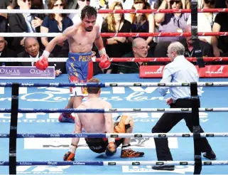  ??  ?? Manny Pacquiao of the Philippine­s watches as Jeff Horn of Australia hits the canvas. (Reuters)