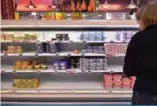  ??  ?? This file photo taken on October 25, 2017 shows a woman looking at an empty refrigerat­ed supermarke­t shelf which normally display butter packets in Saint-Sebastien-surLoire, western France. —AFP