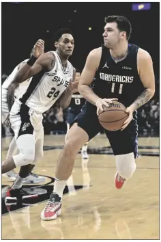  ?? DARREN ABATE/AP ?? DALLAS MAVERICKS’ LUKA DONCIC (RIGHT) drives against San Antonio Spurs’ Devin Vassell during the first half of a game on Wednesday in San Antonio.