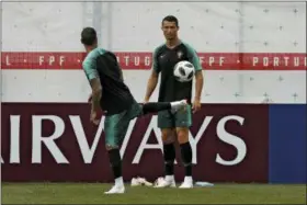  ?? FRANCISCO SECO — THE ASSOCIATED PRESS ?? Portugal’s Cristiano Ronaldo, right, plays the ball with teammate Ricardo Quaresma during Portugal’s official training on the eve of the group B match between Portugal and Morocco at the 2018 soccer World Cup, in Kratovo, outskirts Moscow, Russia...