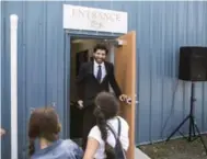  ??  ?? Chocolatie­r Tareq Hadhad greets children at the door of Peace By Chocolate’s newly-opened factory in Antigonish.