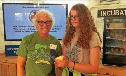  ?? CHAD FELTON — THE NEWS-HERALD ?? Lake County Fair director/board member Georgianne Adams, left, stands with her granddaugh­ter, Makenna, at the chicken hatchery on July 28.