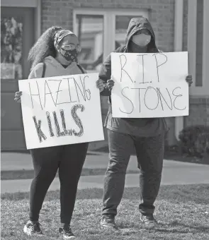  ??  ?? BGSU students Aarian Lynn, left, and Dannie Ellis join the protest calling for enforcemen­t of anti-hazing rules near the Pi Kappa Alpha fraternity at Bowling Green State University.