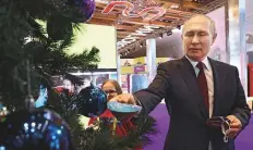  ?? Reuters ?? Putin picks a decoration badge with a child’s request hanging on a New Year’s tree at a charity event in Moscow yesterday.