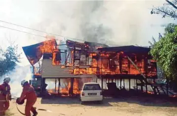  ??  ?? ANGGOTA bomba berusaha memadamkan kebakaran rumah papan di Tuaran, semalam.