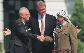  ?? AP ?? Former Israeli prime minister Yitzhak Rabin, left, and the late Palestinia­n leader Yasser Arafat, right, shake hands on the 1993 Oslo peace accords at the White House with Bill Clinton