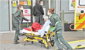  ?? — AFP photo ?? Paramedics take a patient out of their ambulance and into the Royal London Hospital in east London.